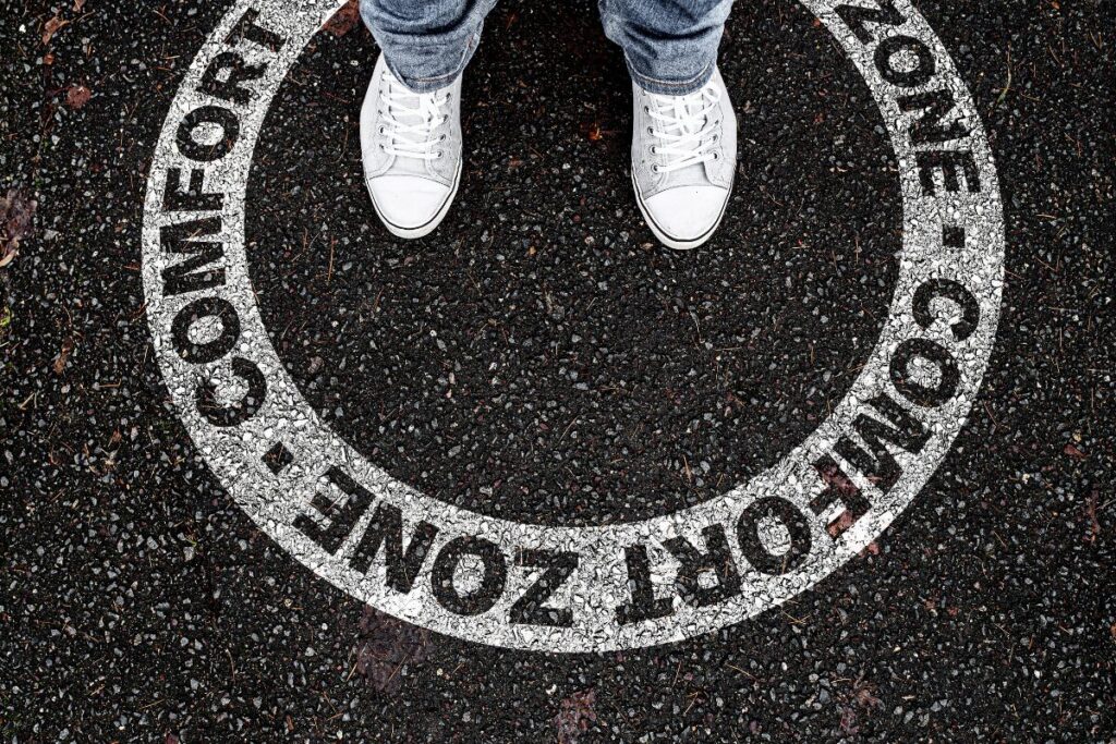 Person standing inside a painted circle labeled comfort zone on the ground