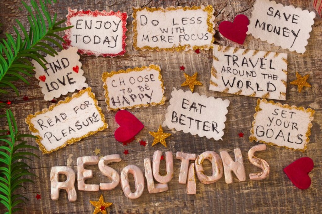 Handwritten resolution notes on a wooden surface with phrases about focus, happiness, and intentional living, representing mindful goal setting.