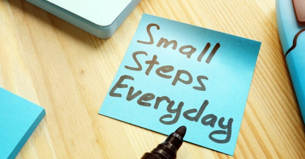 Sticky note on a desk with the handwritten message “Small steps everyday. How to start small when everything feels overwhelming.